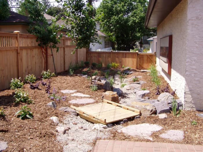 Mulch with stones and a little wooden bridge.