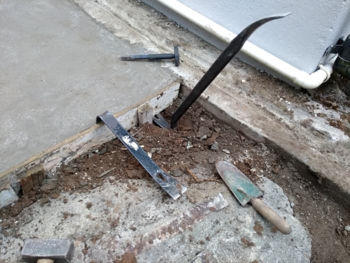 Taking up the formwork from around the edges of a concrete slab, 4 days after it was laid.