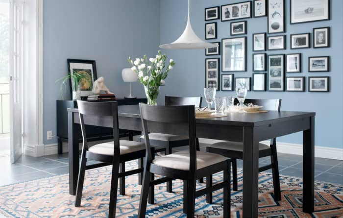 Framed photographs of all different sizes are used to create an attractive collage on this dining room wall.