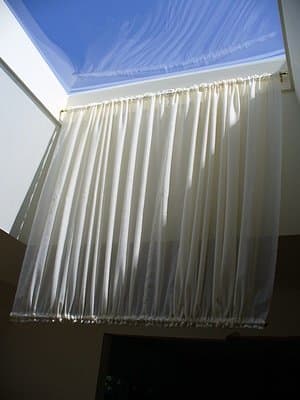 The skylight shade is hanging from one rod with the second rod in. The shirring is even between the 2 rods.