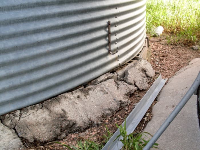 Foundations vary in quality and the details of what may need dealt with to separate them from the bin. On some, it is necessary to go around the outside and "cut" sealing tar with a crow (wonder) bar and a hammer, while lifting the bin.