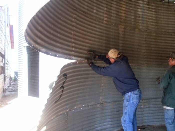 Proceed removing sheets according to how they are lapped, prying or kicking them loose once unbolted, and stack.