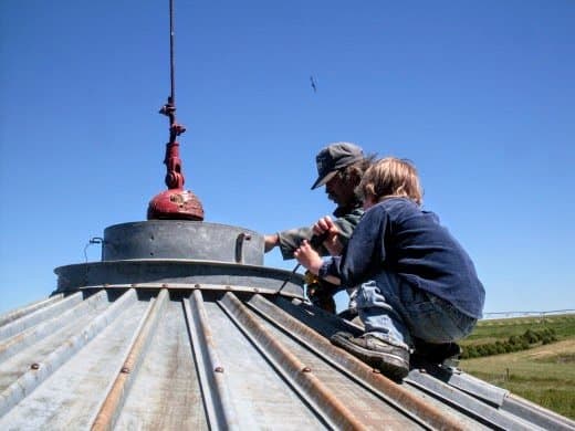While his co-worker continues to work on bolts, my husband begins removing the collar. My son Billy helps unscrew bolts.