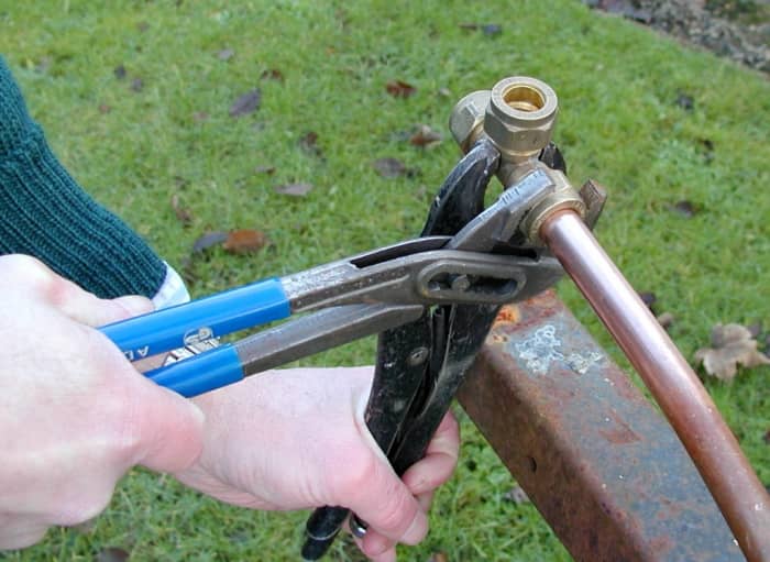 Tightening a nut on a compression fitting with a water pump pliers and vice grips (locking pliers).