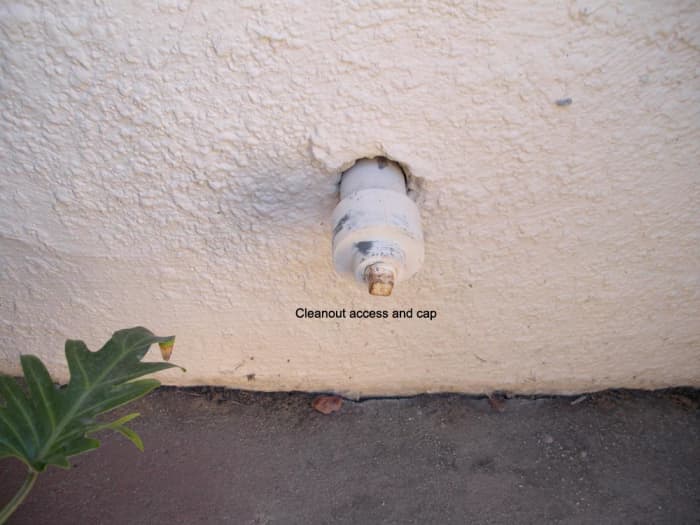 Cleanout access through house wall. These are always low to the ground, and may be hidden behind bushes or other obstructions. Sometimes, they are even in the ground, right above the sewer line.