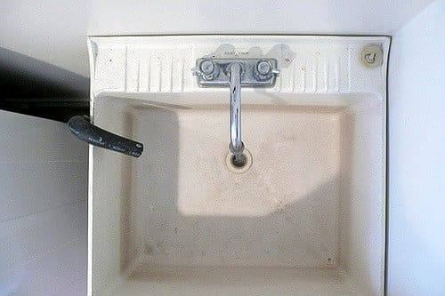 This setup needs a lint catcher. You need to put it over the black pipe coming out from the washer and draining into the sink.