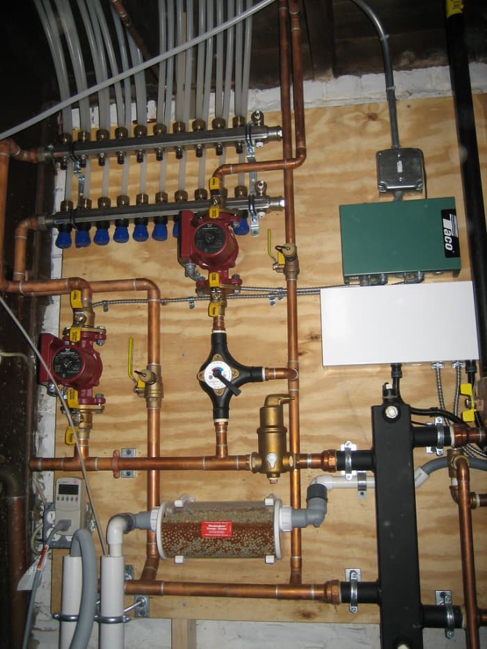 At top, a PEX distribution manifold co-exists right along with copper and other plumbing fixtures to service a boiler and radiant under floor heating system. CCL C