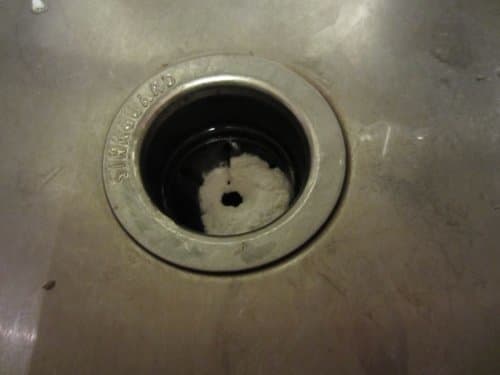 Because I have an annoying plastic cover over my drain, I use 1 cup of baking soda and press as much of it down into my drain as possible.