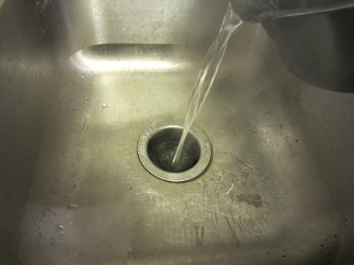 The boiling water flushes the vinegar-baking soda mixture out of the drain, where it will pose no threat to the environment.