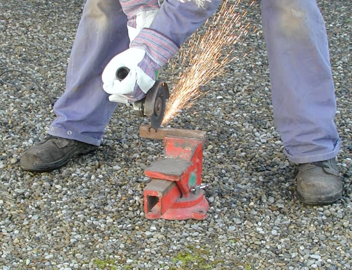 Keep your feet spread apart for stability. You can let the sparks fly backwards between your legs, alternatively you can stand to one side of the workpiece.