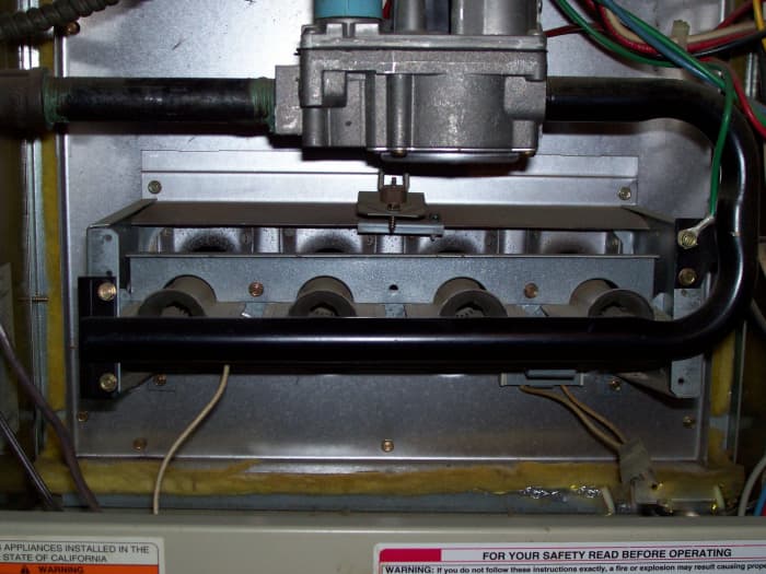 This furnace has four burner ports. Between the first and second burner ports (from left to right) you can see the wire leading to the flame sensor.