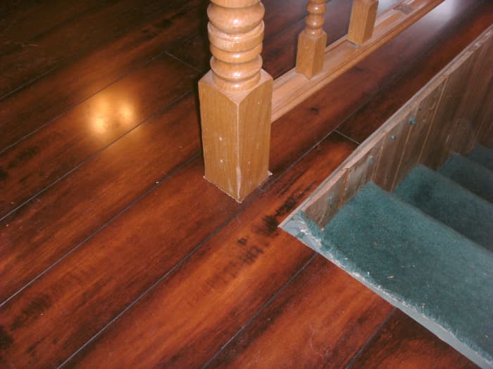 This bannister post goes through the center of a plank; if a hole is cut for it in the middle of a plank it cannot be lowered into place.