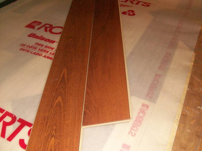 Tipping one plank into another that is laid on the floor. Insert the second plank into the groove and "wiggle" it down flat to the floor.