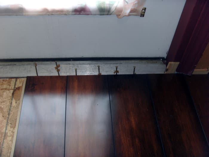 This section is in front of french doors, so nails were driven just outside the flooring into the subfloor to maintain the spacing. Eventually a custom made transition piece will be made to go from flooring to threshold.