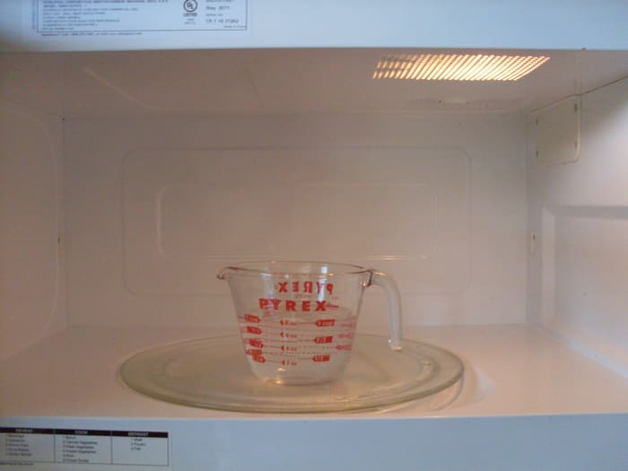 Mix water and vinegar together in a cup, boil for two minutes in the microwave, let sit for fifteen, then wipe down.