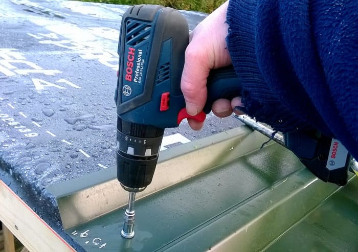 18 volt Bosch professional series cordless combi drill, used here for driving TEK screws to attach metal roof cladding.