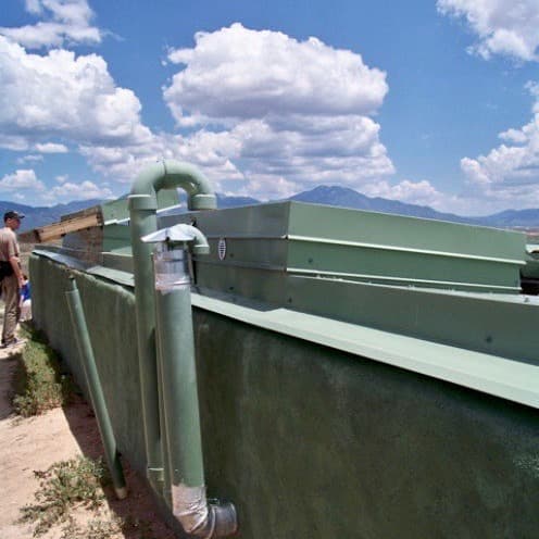 Solar Water Heater - The pipe leading to the bottom of the solar panel supplies it with cold water. The pipe emerging from the top of it carries heated water down to a hot water tank inside the house.
