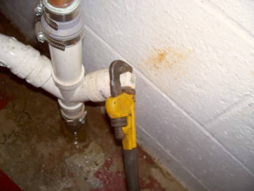 Access the clean-out port. To remove, simply unscrew using a wrench.