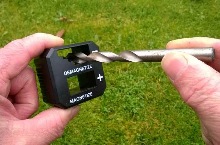 A de-magnetizing tool removes magnetism from a drill bit