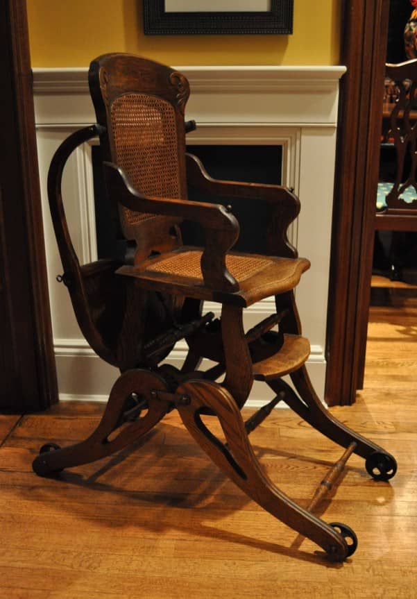 This is an original version of my antique high chair. This pristine chair features all-original parts, including the original wheels, caning, and overhead tray.