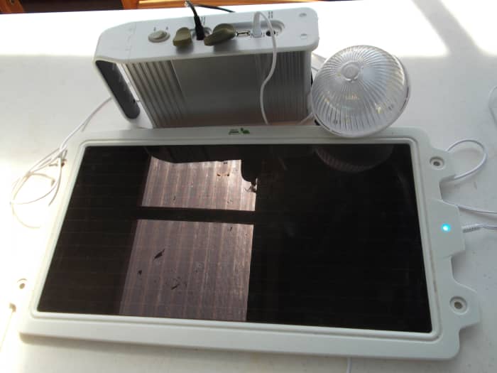 Taken outside in the undercover area, the reflection in the solar panel is a clear section of the roof above. Note the small blue light on the right side indicates the panel is charging even in low light.