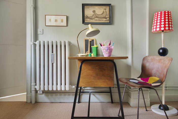 The lamp, seat cushion, and desk items bring color to the small office area of the living room without overwhelming the space.