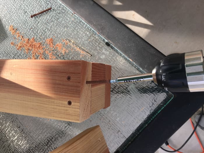 Showing a little angle on one of the screws that will secure the front vertical 2x4 to the lower front of the riser, in order to miss the already installed screw.