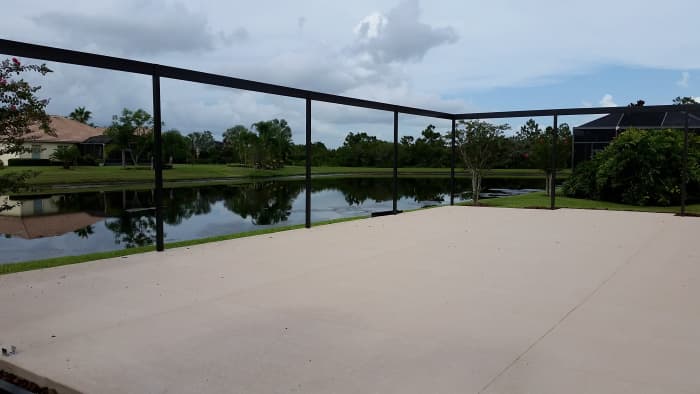 The screen room in the first stage. They drill into the concrete and place brackets for the upright parts. The aluminum is notched to interlock for the cross beams.