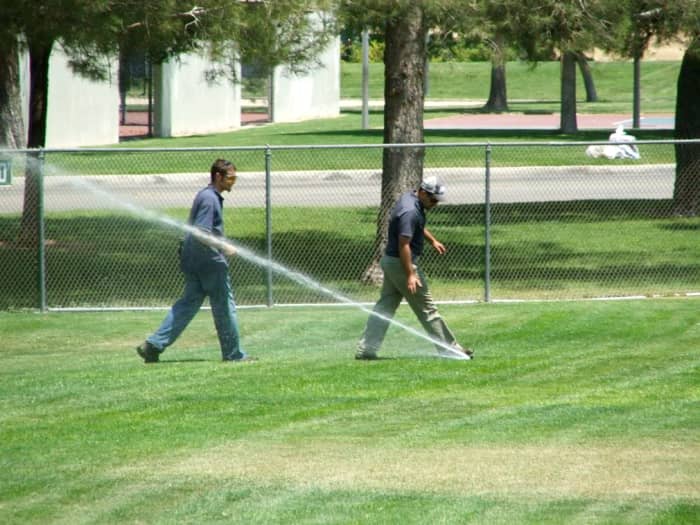 Take a notepad and pen. Have a partner turn on each irrigation station and note which sprinklers are not working. Look for flooded areas and water running into the drain. Make sure the controller is working properly. Make any repairs you need to.