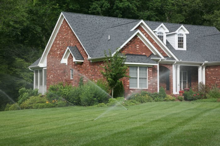 Watering a lawn during its growing season keeps it healthy and vibrant.