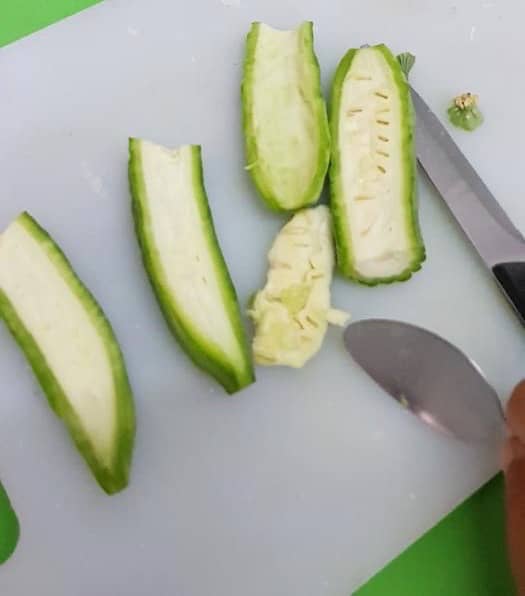 Cut the halves into quarters, length-wise this time, and scrape the pith (the guts in the middle) out with a spoon.