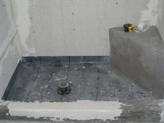 Notice the wall boards do not extend down to the bottom of the shower membrane.