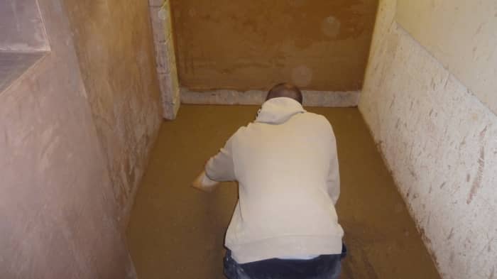 Dry pack the shower floor with either a grout float or a flat trowel.