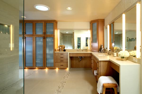 This bathroom has an excess of recessed cans, vanity light bars and ceiling fixtures. Vanity sconces in addition to overhead lights give the space uniform illumination.