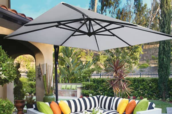 An offset cantilever umbrella base is positioned on the side rather than in the middle of a seating area.