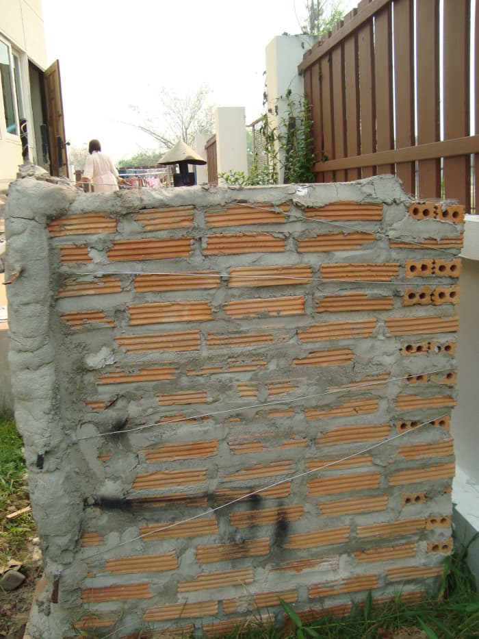 Attaching the door: The ledge supports the weight of the door. The wire keeps it from falling over and the concrete seals the cracks. Not pretty, but it works!