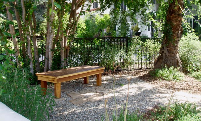 The bench is the main focal point in this landscape, connoting cool shade on a hot summer day. Imagine sitting here with a glass of homemade lemonade while chatting with someone, reading a book, or gazing out at the rest of the garden.