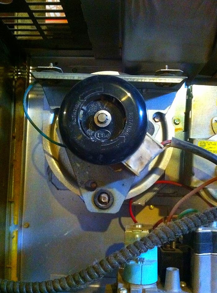 The inducer motor and fan. The fan draws the "bad" exhaust gases out of the heat exchanger and pushes them up into the chimney.