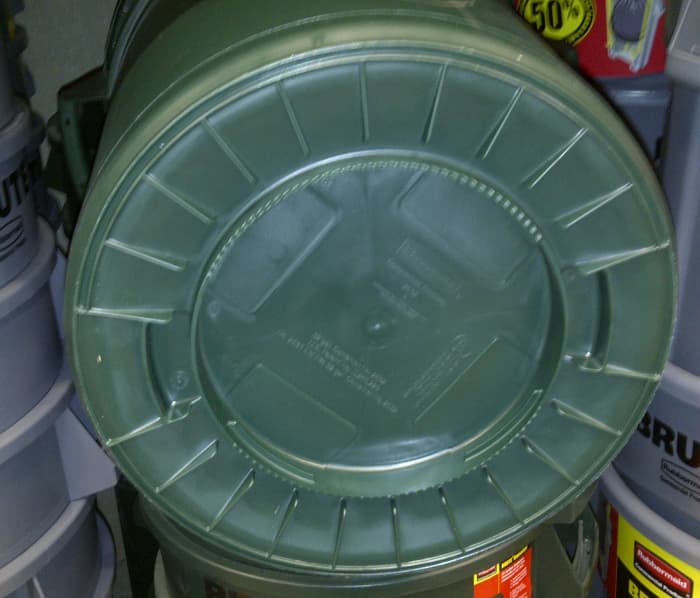 Plastic garbage can with ridges on bottom to resist wearing holes though the bottom