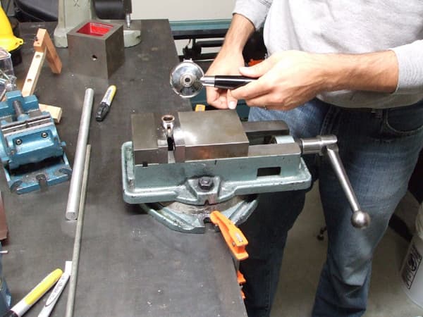 The spout threaded on the portafilter with a thread-locker. Using a vise makes unscrewing the spout much easier.