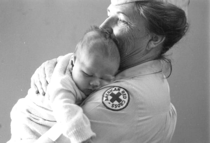 Berenice Warner, Red Cross Hospital Field Director, Navy Regional Medical Center, holds a Vietnamese infant