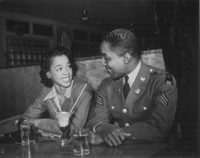 "Sergeant Franklin Williams, home on leave from Army duty, with his best girl Ellen Harden, splitting a soda"
