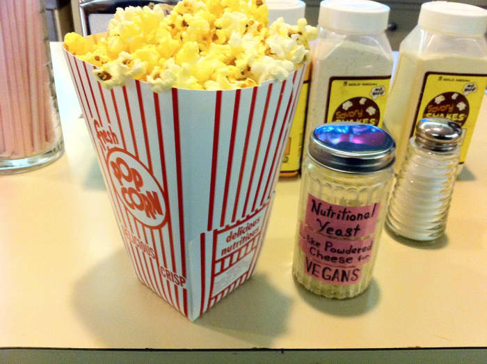 Say, "no" to the greasy oil and over-salted theater popcorn. Instead, opt for a sprinkle of cheesy tasting nutritional yeast with a little sea salt.