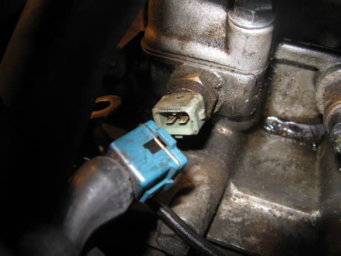 Most coolant temperature sensors resemble a large nut with an electrical connector on top.