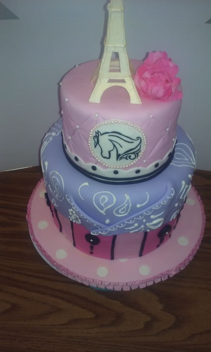 Here is a great example of using several different mediums to achieve my vision. The Paris cowgirl themed cake is covered in different layers of fondant, the bandanna has hand piped royal icing detail on top, the Eiffel Tower and peony were made from