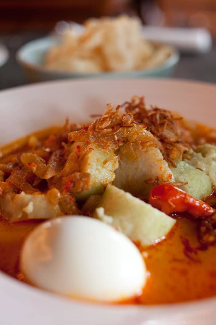 Lontong sayur: rice cakes in coconut and vegetable sauce served for breakfast with fried shallots and prawn crackers