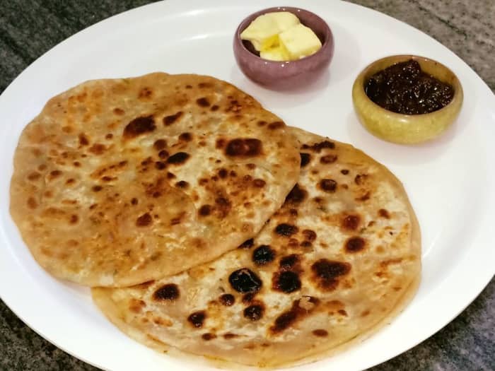 Aloo paratha is a traditional Punjabi breakfast dish, usually served with butter, lemon or mango pickle, and lassi.