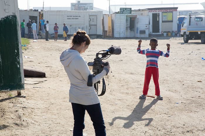 Townspeople look on during the filming of a documentary about Sinenjongo High School in Joe Slovo Park, Cape Town, South Africa.