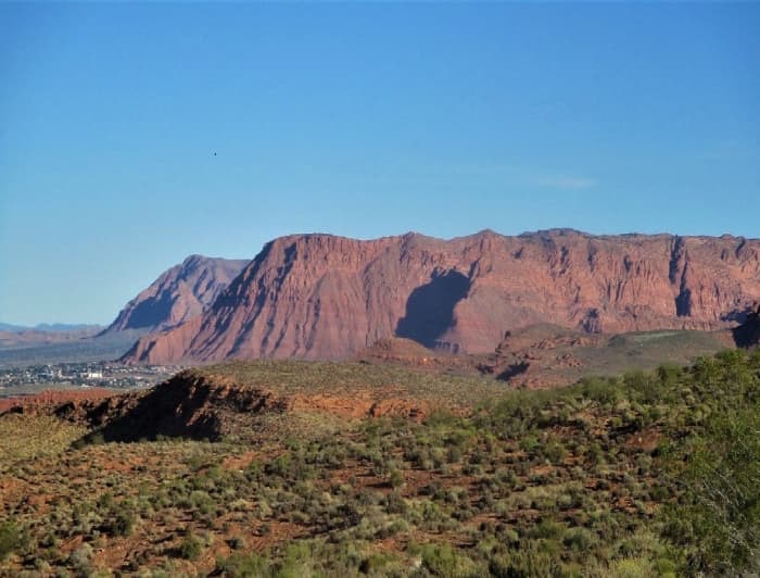 These distant red hills are visible from the City Creek Trail in Saint George, Utah. The small town nestled at the base of the hills is Ivins.