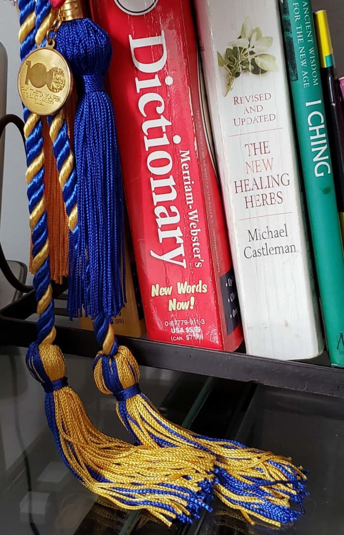 Honors cords from two of my degrees, along with an old dictionary from a primary school teacher, an herbal text, and a copy of the I Ching.